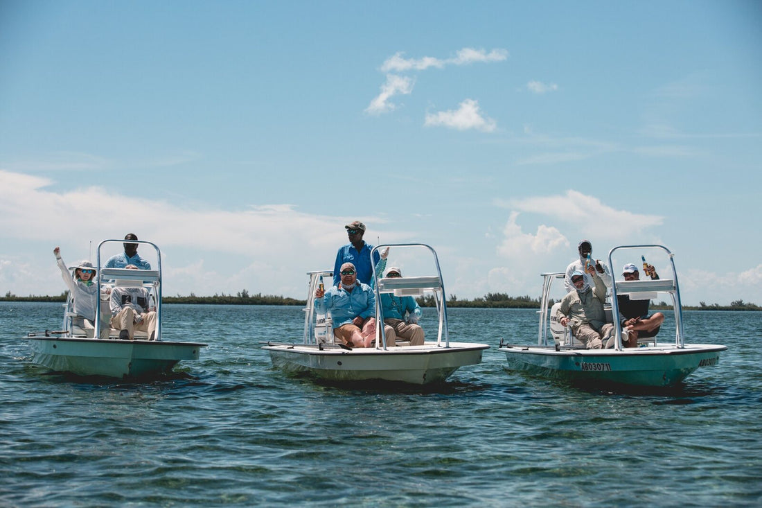Three skiffs with artists and guides gathered on the flats near Blackfly Lodge, Abaco